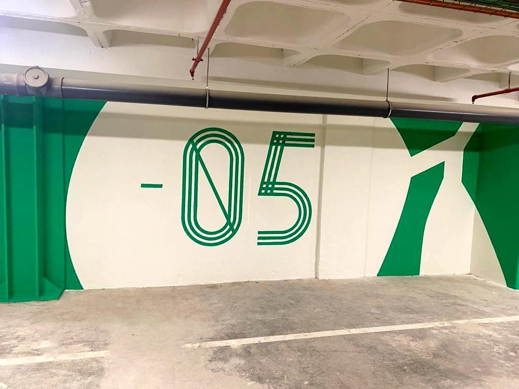 Pintura em parque de estacionamento para sinalética direcional e informativa